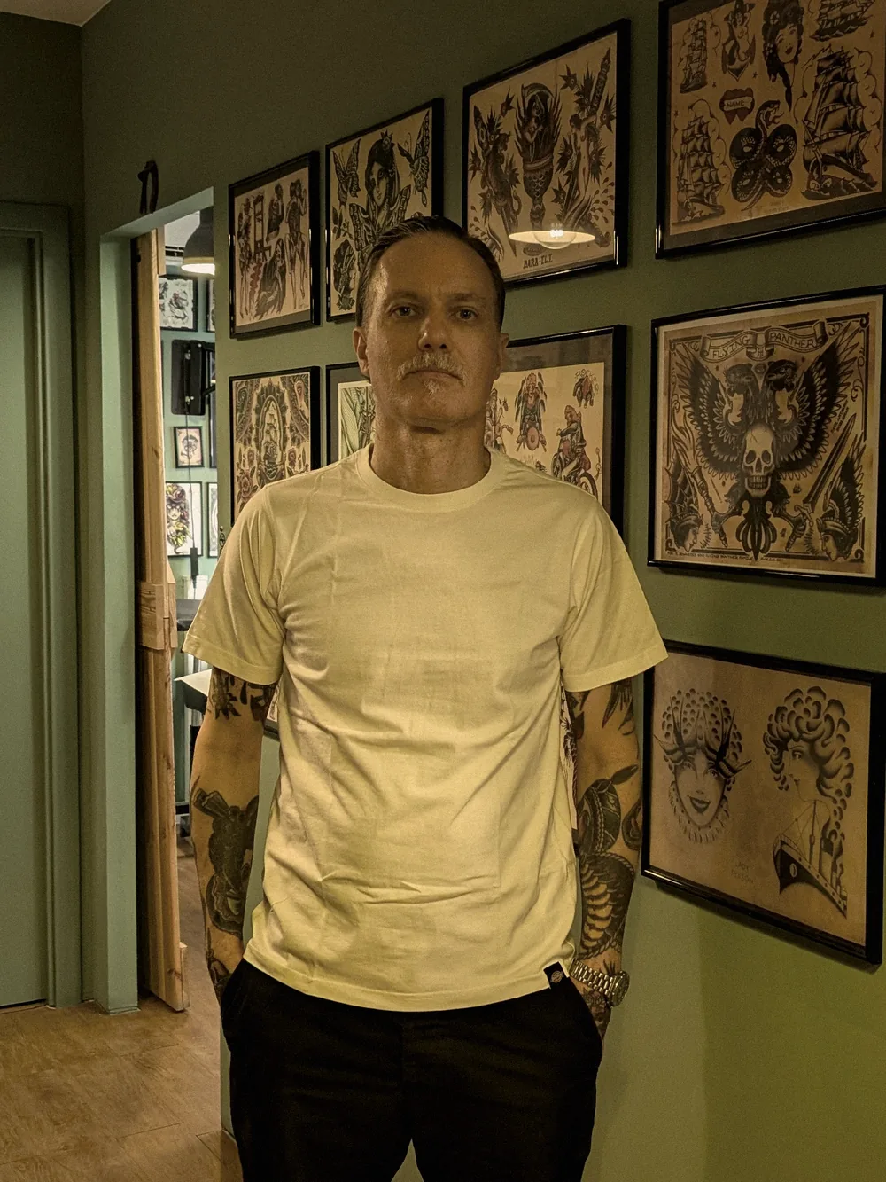 Leo Martínez de cuerpo entero en el pasillo de A Sailor's Grave Tattoo, su estudio privado en Granollers (Barcelona).