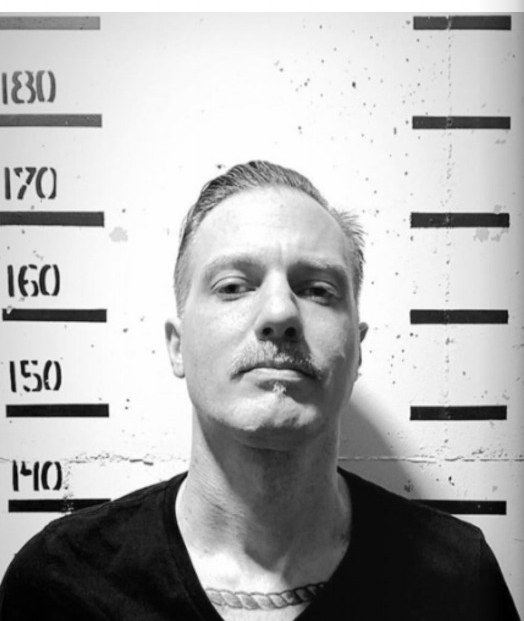 Leo Martínez, retrato editorial con regla de altura detrás