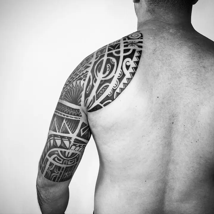Tatuaje tribal polinesio en hombro y brazo, diseñado a mano alzada por Leo Martínez en A Sailor's Grave Tattoo, Granollers (Barcelona).