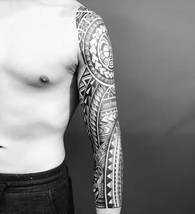 Tatuaje tribal polinesio en manga completa de brazo, diseñado a mano alzada por Leo Martínez en A Sailor's Grave Tattoo, Granollers (Barcelona).