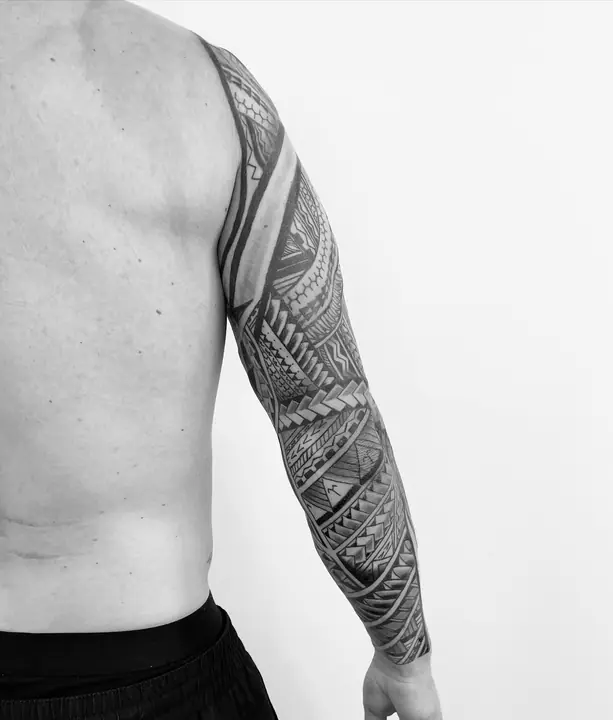 Tatuaje tribal polinesio en manga completa de brazo, diseñado a mano alzada por Leo Martínez en A Sailor's Grave Tattoo, Granollers (Barcelona).