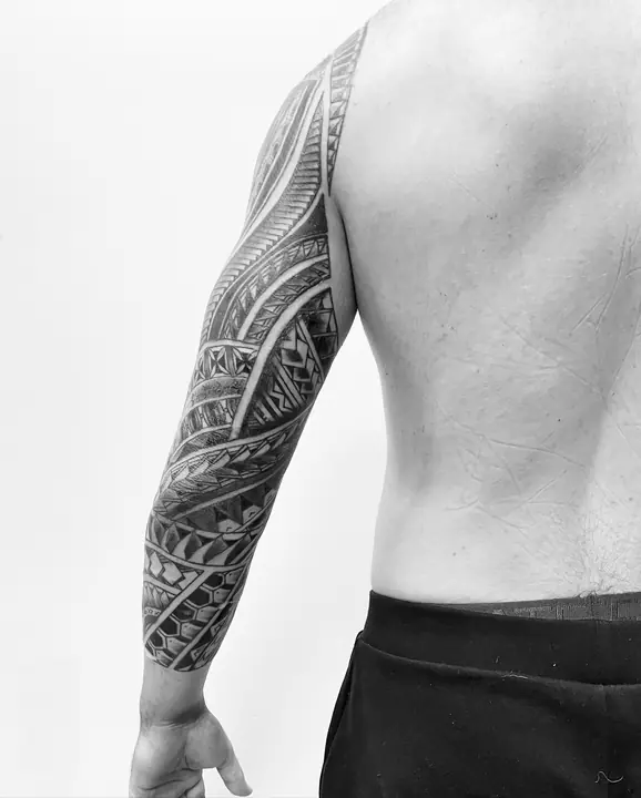 Tatuaje tribal polinesio en manga completa de brazo, diseñado a mano alzada por Leo Martínez en A Sailor's Grave Tattoo, Granollers (Barcelona).