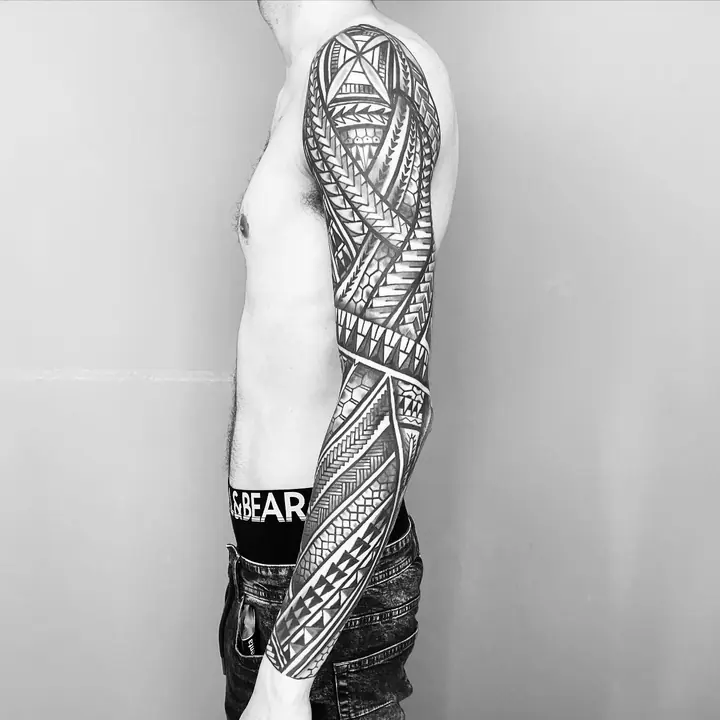 Tatuaje tribal polinesio en manga completa de brazo, diseñado a mano alzada por Leo Martínez en A Sailor's Grave Tattoo, Granollers (Barcelona).