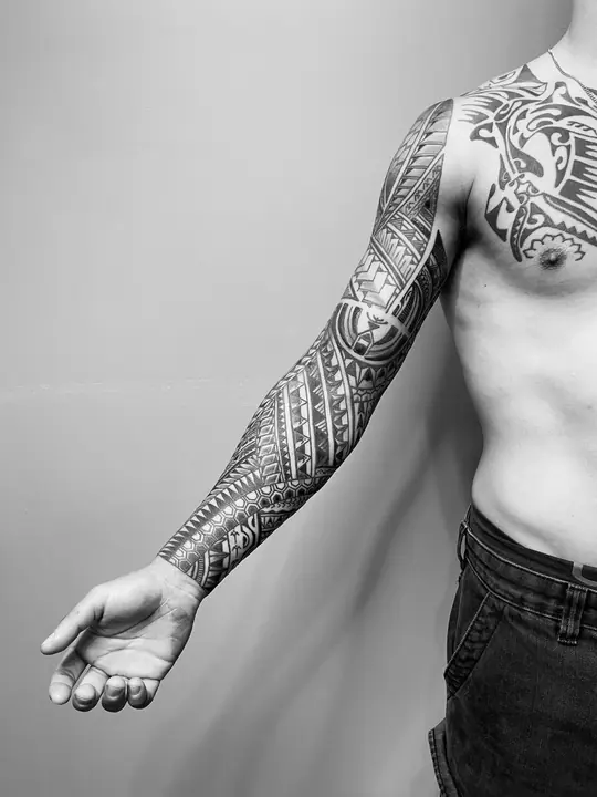 Tatuaje tribal polinesio en manga completa de brazo, diseñado a mano alzada por Leo Martínez en A Sailor's Grave Tattoo, Granollers (Barcelona).