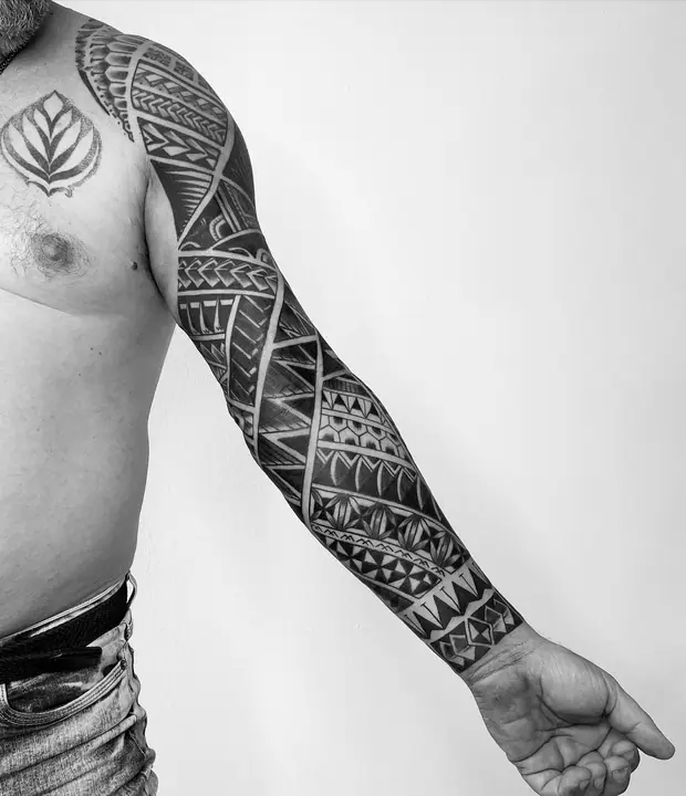 Tatuaje tribal polinesio en manga completa de brazo, diseñado a mano alzada por Leo Martínez en A Sailor's Grave Tattoo, Granollers (Barcelona).