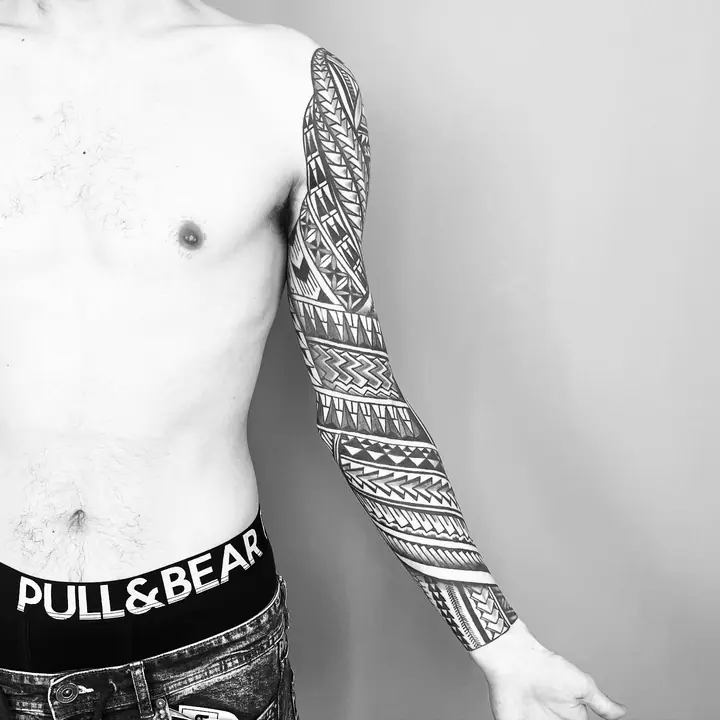 Tatuaje tribal polinesio en manga completa de brazo, diseñado a mano alzada por Leo Martínez en A Sailor's Grave Tattoo, Granollers (Barcelona).