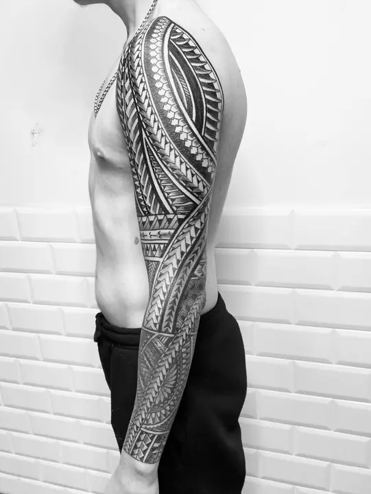 Tatuaje tribal polinesio en manga completa de brazo, diseñado a mano alzada por Leo Martínez en A Sailor's Grave Tattoo, Granollers (Barcelona).