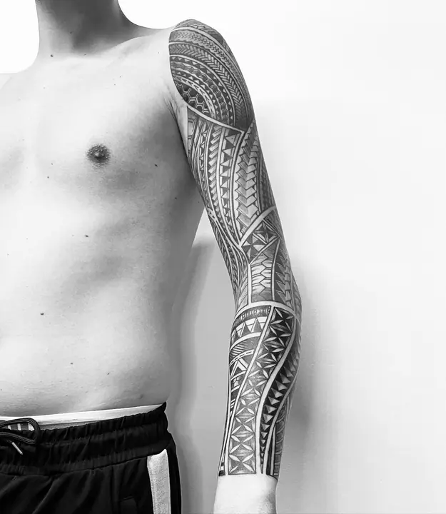 Tatuaje tribal polinesio en manga completa de brazo, diseñado a mano alzada por Leo Martínez en A Sailor's Grave Tattoo, Granollers (Barcelona).