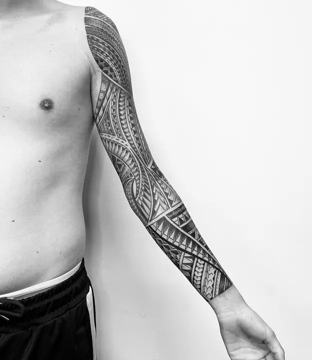 Tatuaje tribal polinesio en manga completa de brazo, diseñado a mano alzada por Leo Martínez en A Sailor's Grave Tattoo, Granollers (Barcelona).