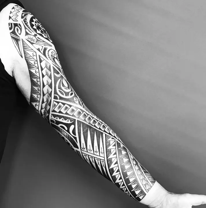 Tatuaje tribal polinesio en manga completa de brazo, diseñado a mano alzada por Leo Martínez en A Sailor's Grave Tattoo, Granollers (Barcelona).