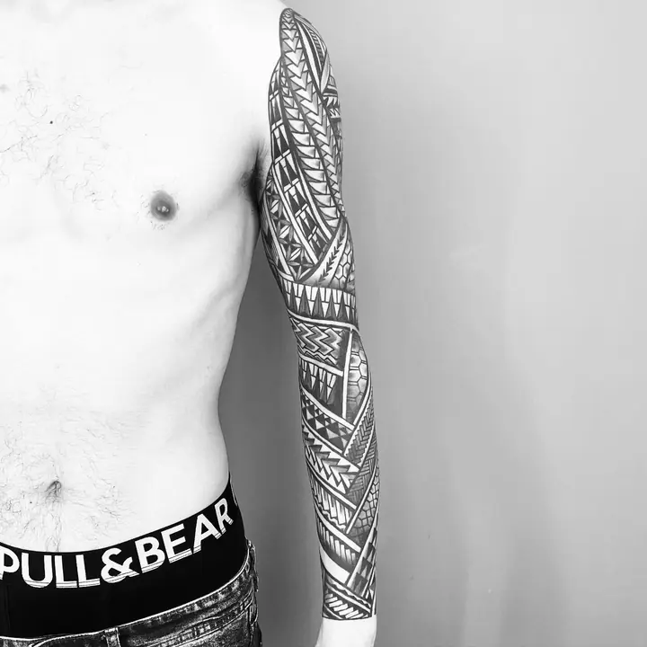 Tatuaje tribal polinesio en manga completa de brazo, diseñado a mano alzada por Leo Martínez en A Sailor's Grave Tattoo, Granollers (Barcelona).