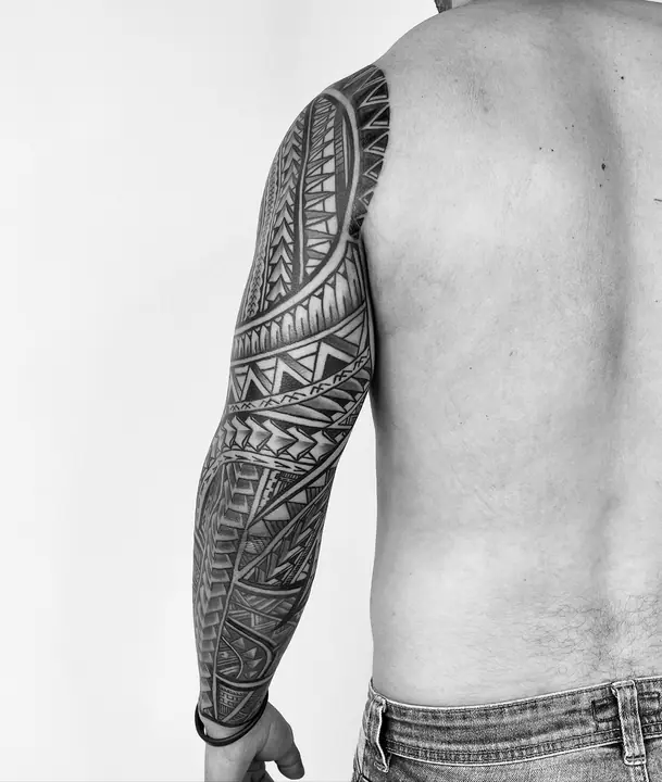 Tatuaje tribal polinesio en manga completa de brazo, diseñado a mano alzada por Leo Martínez en A Sailor's Grave Tattoo, Granollers (Barcelona).